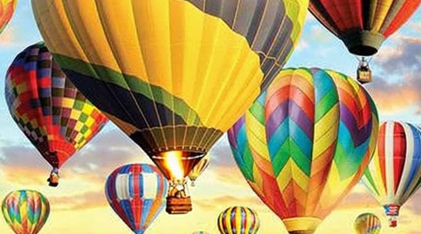 Hot air balloons drifting over a lavender field at sunrise, a burner firing inside the largest balloon